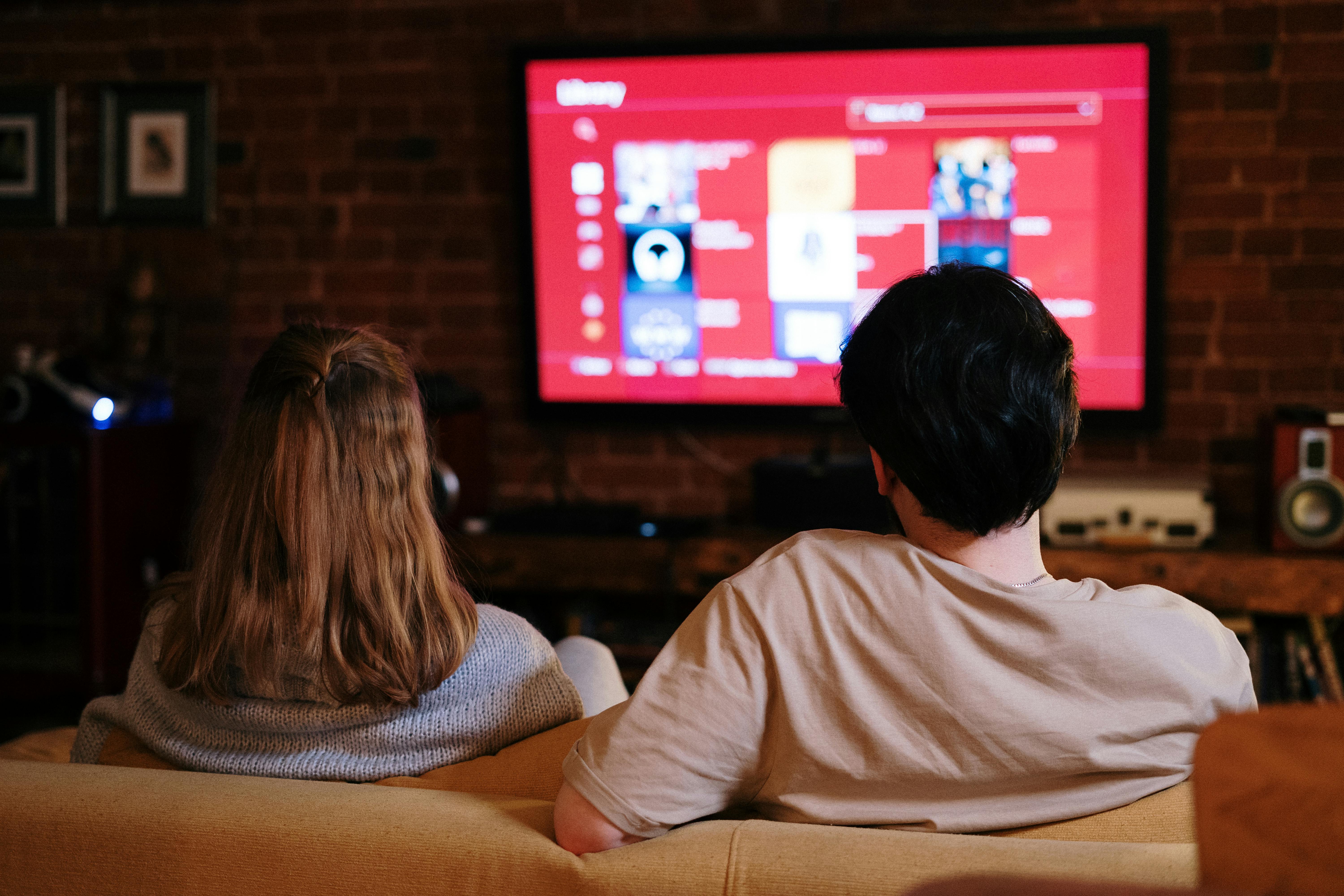 A couple watching content on AppCoreX from a cozy living-room couch